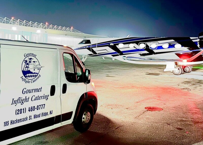 Gourmet Inflight Catering van parked in front of an airplane